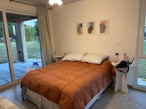 a bedroom with a bed with an orange blanket at Quinta Narbaiz in Estación Nueve de Julio Sur