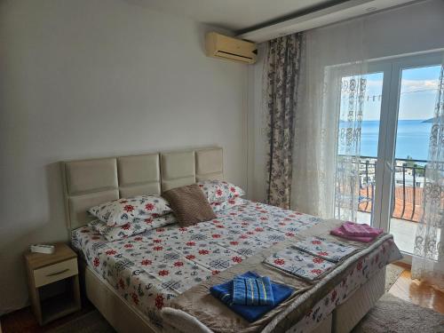 a bedroom with a bed with a view of the ocean at Rooms Vlaovic in Herceg-Novi