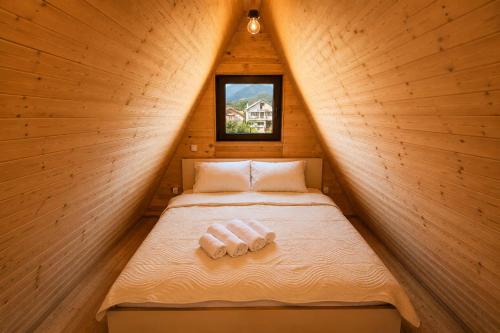 a small bed in a wooden cabin with a window at Wooden Cabin 1 with Pool Access - Bate Bole Resort in Ohrid