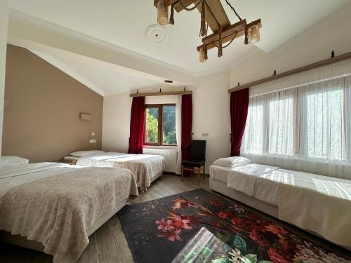 a bedroom with three beds and a window at Mersu Ala Konak Otel maşukiye sapanca in Kocaeli