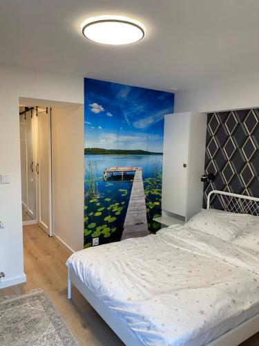 a bedroom with a bed and a painting of a pier at Natalia 2 in Mrągowo
