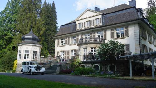 an old car parked in front of a house at Landsitz Kammerburg - Villa in Lorch am Rhein