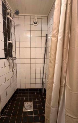 a bathroom with a shower and a tiled floor at Daltorps skola, Övernattningsstuga H, Self check in, Übernachtungskabine H in Skövde