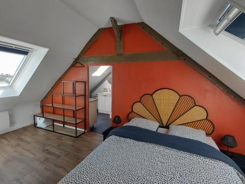 a bedroom with a large bed with an orange wall at Duplex sur la Baie in Saint-Benoît-des-Ondes