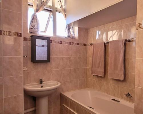 a bathroom with a sink and a toilet and a tub at Scottburgh Views 707 Seafront Apartment in Scottburgh