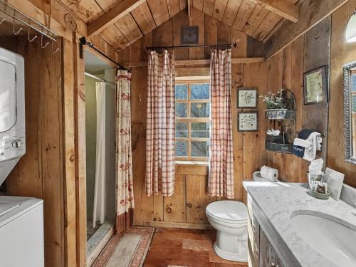 a bathroom with a toilet and a sink and a window at Melrose Cabin in Highlands