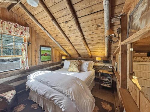 a bedroom in a log cabin with a bed at Melrose Cabin in Highlands