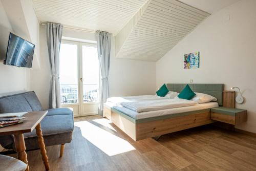 a bedroom with a bed and a couch and a table at Strengen Guesthouse in Caldaro