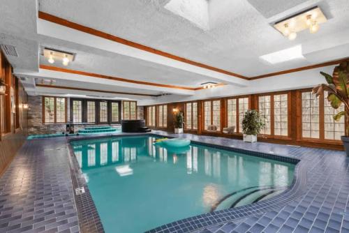 a large swimming pool with blue water in a building at Genteman Manor Private Indoor Pool Sauna & Lake in Sainte-Agathe-des-Monts