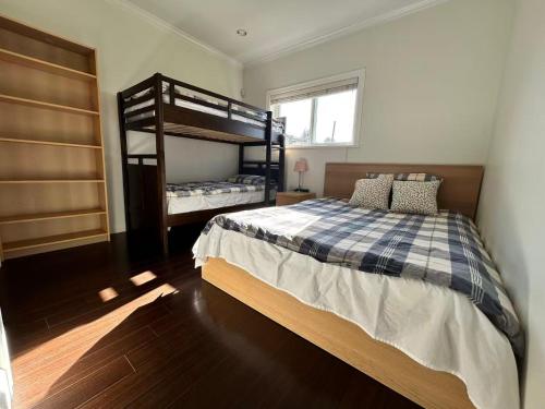 a bedroom with two bunk beds and a window at Spacious 2 Bedroom Suite in Burnaby Free Parking, Full Kitchen, Near Transit in Burnaby