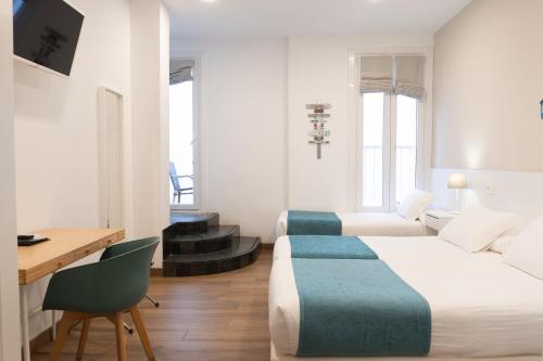 a hotel room with a bed and a desk and a couch at Pensión Txiki Polit in Zarautz