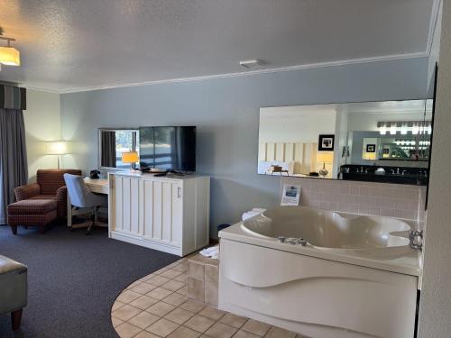 a large bathroom with a tub and a living room at River House Inn, a Baymont by Wyndham in Florence