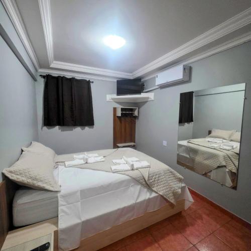 a small bedroom with a bed and a mirror at Arion Hotel Sapopemba in São Paulo