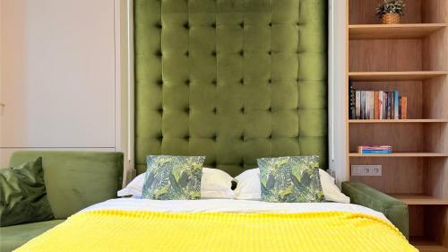 a bedroom with a green headboard and a bed with pillows at Ruzop Apartament - Modern studio in center, self check-in, WiFi in Poznań