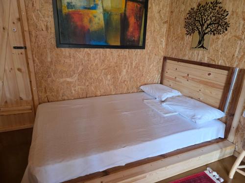 a small bed in a room with a wooden headboard at Wooden House at the Mountain-private in Paránimfoi