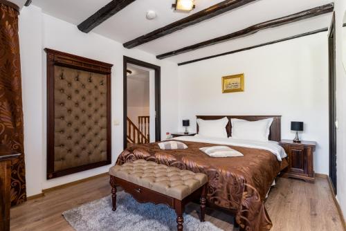 ein Schlafzimmer mit einem großen Bett und einer Bank darin in der Unterkunft Casa Dudu in Moieciu de Jos