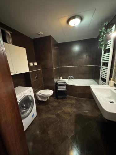 a bathroom with a toilet and a sink and a washing machine at Sea Towers in Gdynia