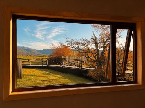 a window with a view of a field and mountains at Geikie Lodge in Torres del Paine