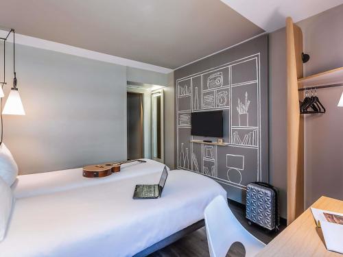 a hotel room with a bed and a tv at Hotel ibis Lisboa Liberdade in Lisbon