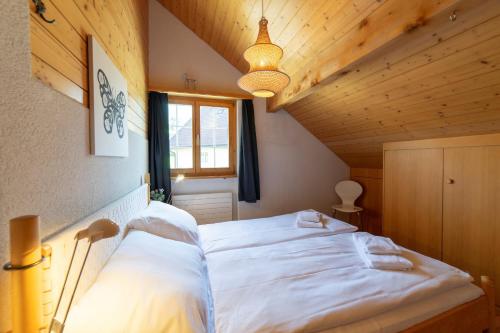 a bedroom with a large white bed in a attic at Dachnest in Unterwasser