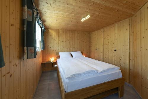 a bedroom with a bed in a wooden room at Bergpanorama in Wildhaus