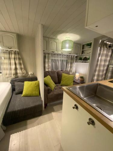 a kitchen and living room with a couch and a sink at Camping Abordaż Wolin in Kołczewo