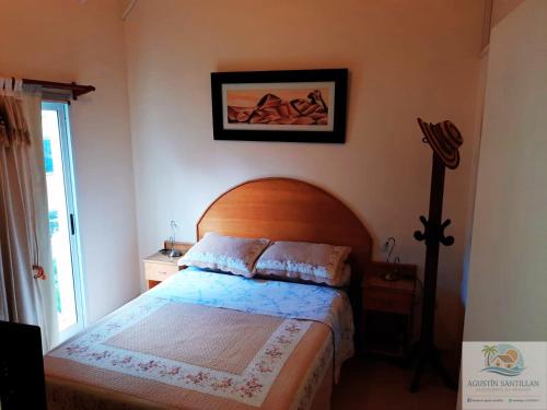 a bedroom with a bed with a wooden head board at Duplex in Pinamar