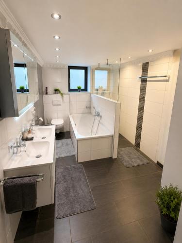 a bathroom with a tub and a sink and a bath tub at Gemütliche Ferienwohnung in Hackenheim