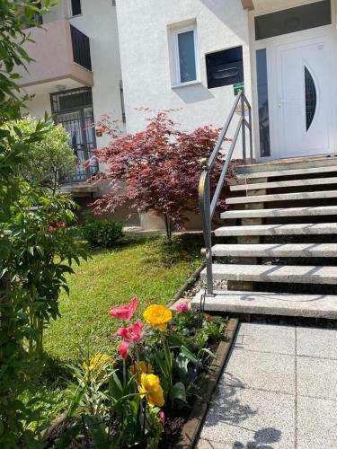 a house with stairs and flowers in front of it at Holiday Home Ilidza Rose in Sarajevo