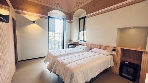 a bedroom with a large bed with white sheets at Casale della Vittoria - Guest House in Taranto