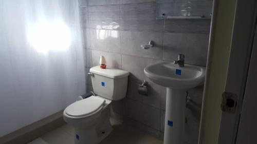 a bathroom with a toilet and a sink at Hotel Rosangel in Estero Hondo