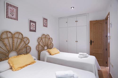 two beds in a room with white walls at ESTRELLA de la SIERRA in Arroyo Frio