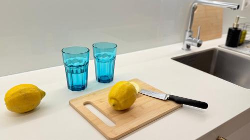a cutting board with lemons and two glasses of water at Ruzop Apartament - Modern studio in center, self check-in, WiFi in Poznań