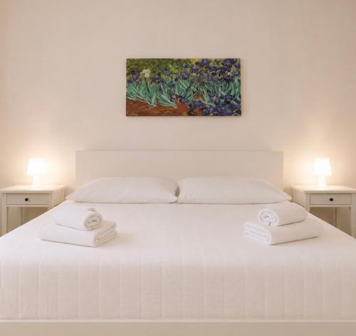 a bedroom with a white bed with two towels on it at Centro A Casuzza in Palermo