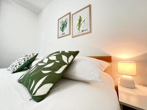 a bedroom with a bed with green and white pillows at Rab City Apartment Greeny in Rab