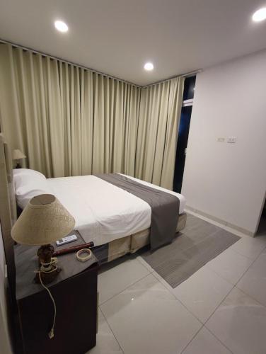 a bedroom with a bed and a table with a lamp at Casa Exclusiva Mar Adentro in Santa Cruz de la Sierra