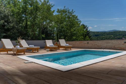a swimming pool with chaise lounge chairs and a swimming pool at MB Villas in Vrnjačka Banja