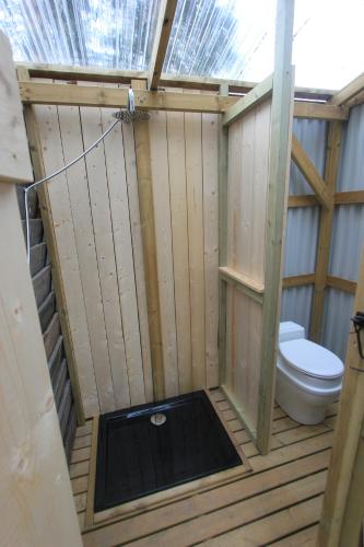 a bathroom with a toilet in a wooden stall at Forest Shed in Åsele