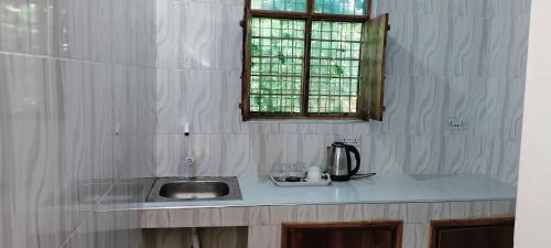 a kitchen counter with a sink and a window at primavera jambiani in Mfumbwi