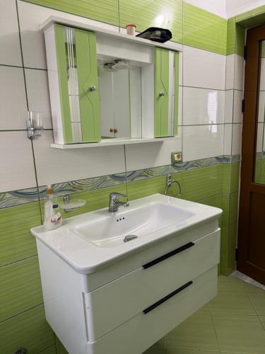 a bathroom with a white sink and a mirror at Guest House Dimos Kristi in Përmet