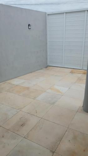 an empty room with white walls and a tile floor at Casinha Larithur in Beberibe