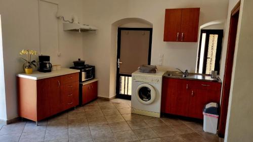 a kitchen with a washer and a washing machine at Studio Marianna & George in Plátanos