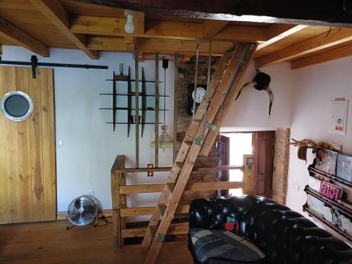 a wooden staircase in a living room with a couch at Casa do Baloiço em Porto de Vacas Aldeias de Xisto in Janeiro de Baixo