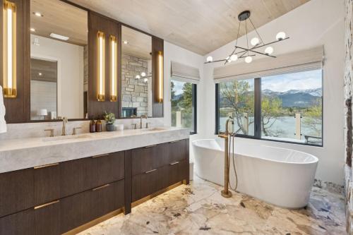 a bathroom with a tub and two sinks and a window at Sisu Lodge by Canmore Premier in Kananaskis Village