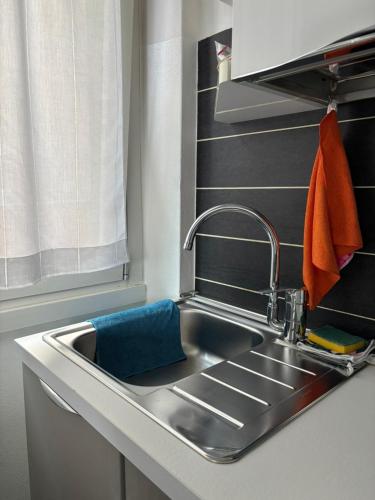 a kitchen sink with an orange towel next to it at Gerenz-home in Lecco