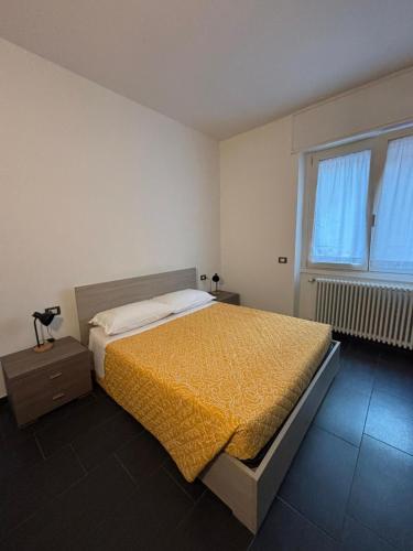 a bedroom with a large bed with a yellow blanket at Gerenz-home in Lecco
