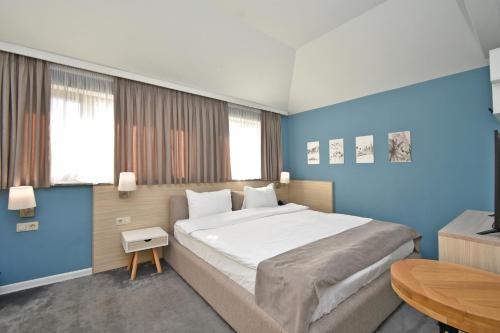 a bedroom with a large bed and a table at In City Hotel in Yerevan