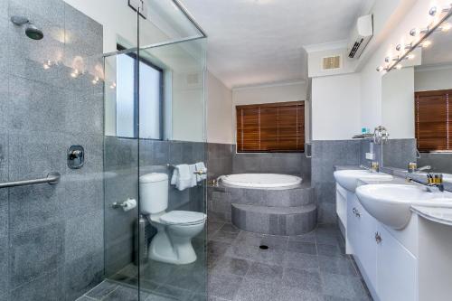 a bathroom with a toilet and a sink and a shower at Sunset Sails Redcliffe in Redcliffe