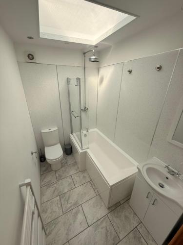 a bathroom with a shower and a toilet and a sink at Flat White in Westward Ho