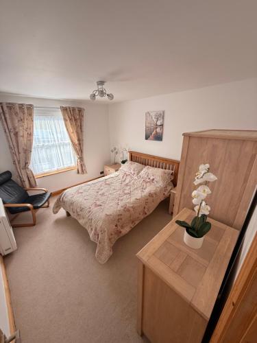 a bedroom with a bed and a table with flowers on it at Flat White in Westward Ho